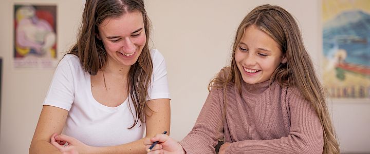 Mentor og elev læser i historiebog