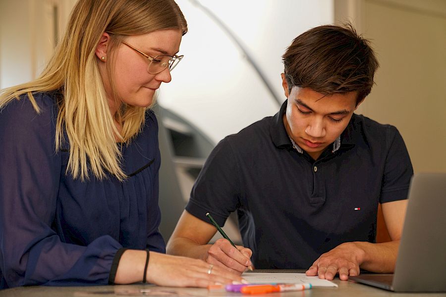 Elev arbejder med fransk grammatik opgaver med sin mentor til undervisning.