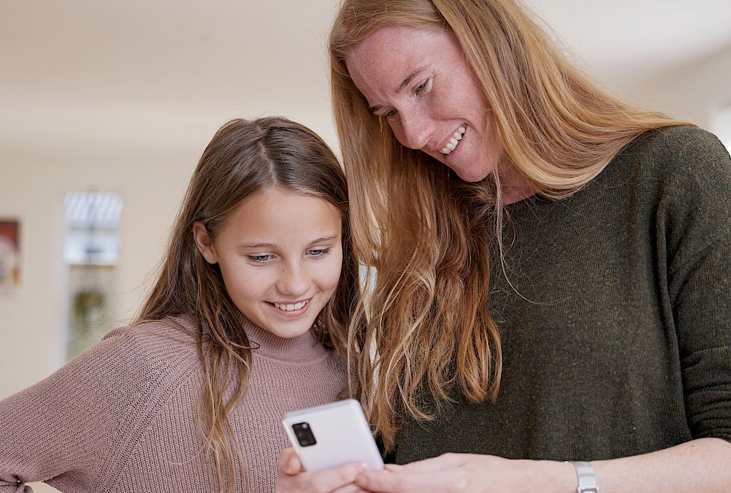Mor og elev kigger på Mentorportalen sammen
