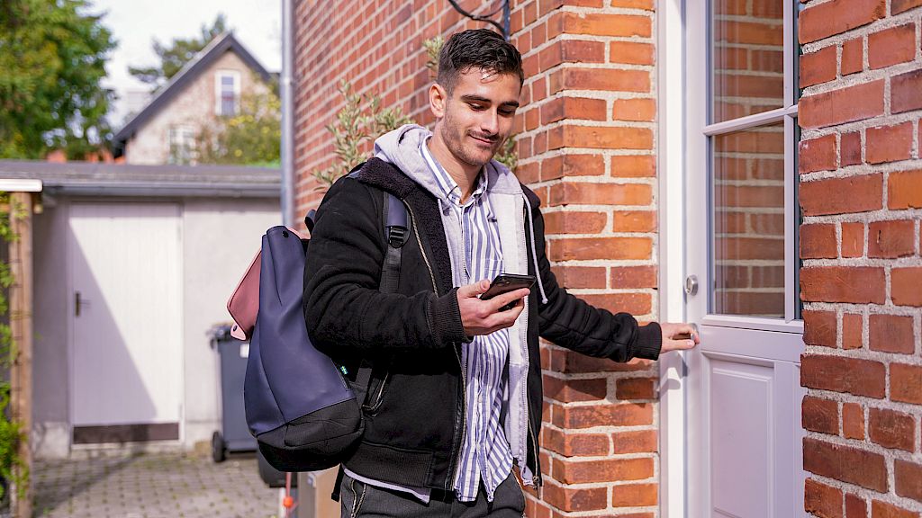 Mentor er på vej til undervisning med sin elev, mens han kigger på sin telefon.