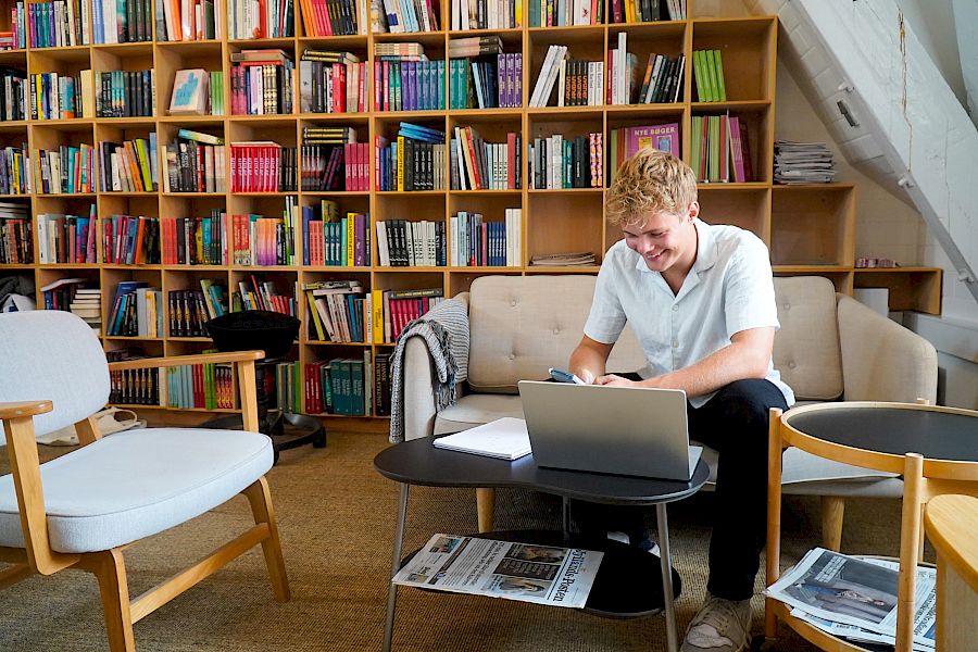 Elev sidder på bibliotek og får undervisning