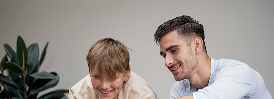 Mentor og elev kigger på dansk opgaver på computeren