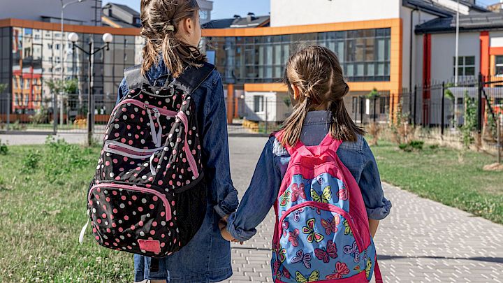 To elever med deres skoletasker på vej i skole