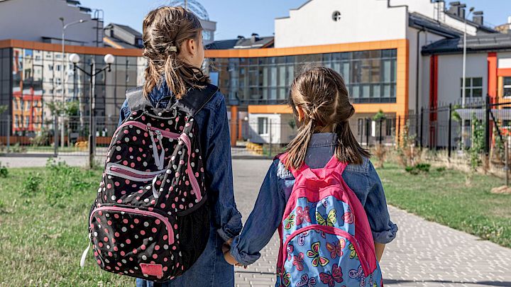 To elever med deres skoletasker på vej i skole