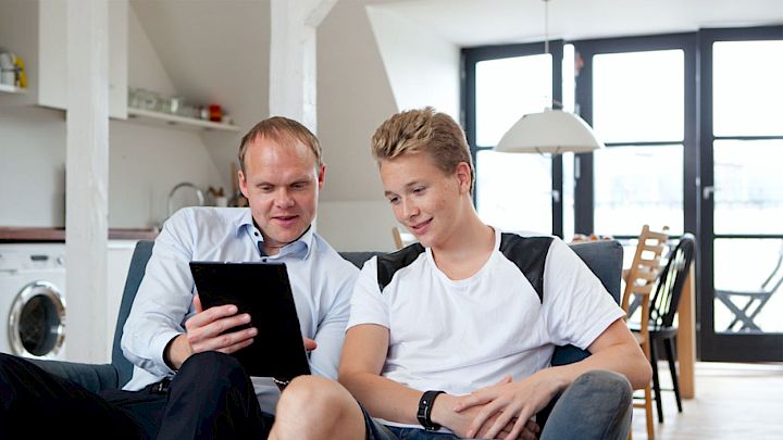 Far og søn kigger på Ipad for at forberede det kommende skoleår