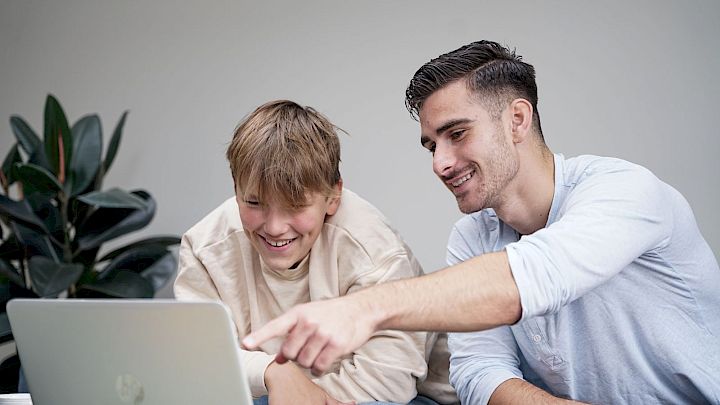 Elev får hjælp af mentor med lektier på computer