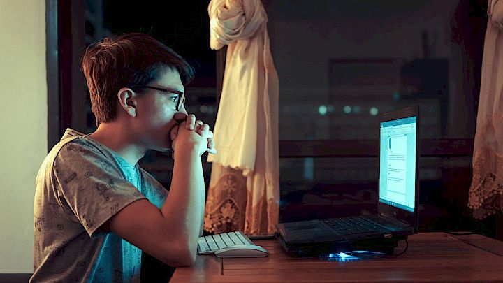 Dreng laver lektier på computer sent om aftenen