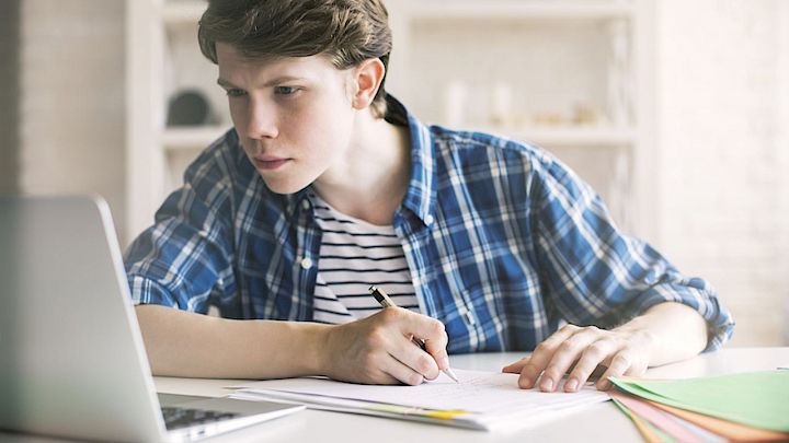 Elev sidder og laver lektier på computer