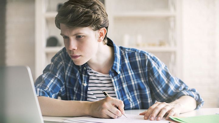 Elev sidder og laver lektier på computer