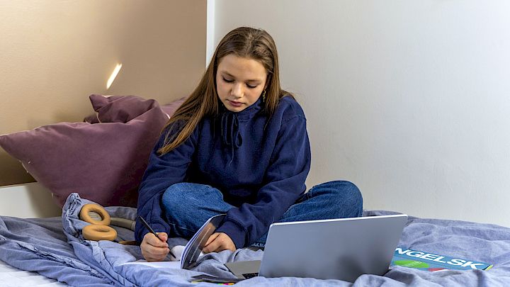 Elev skriver noter i sin notesbog