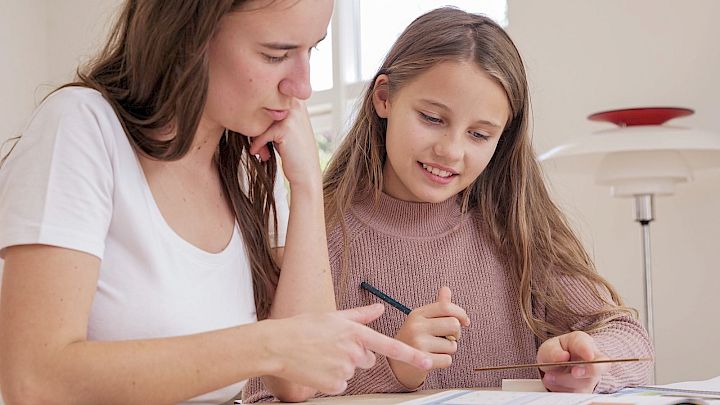 Pige får lektiehjælp af mentor