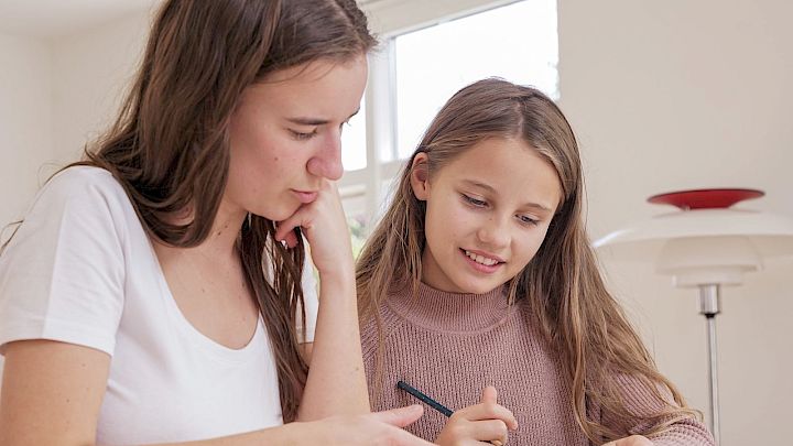 Pige får lektiehjælp af mentor