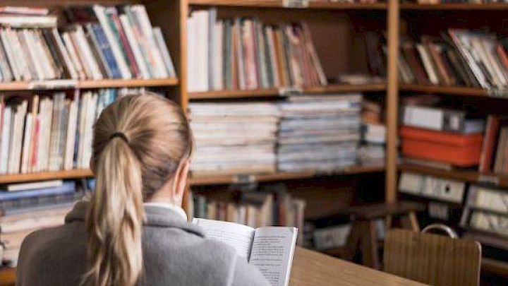 Elev sidder og laver lektier på bibliotek