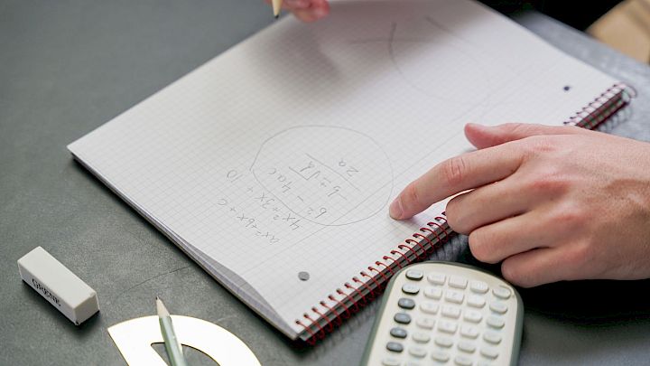 Elev sidder og laver matematik på papir