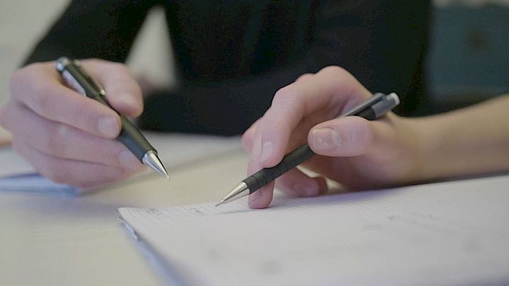 Mentor og elev arbejder på papir