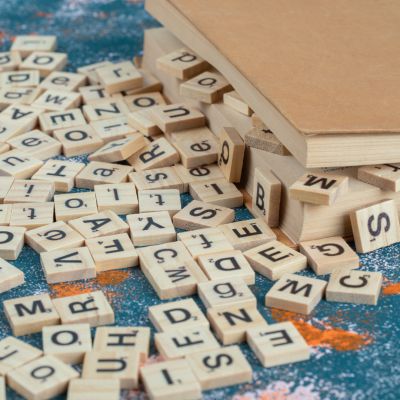 Et billede af små træbrikker med bogstaver 
