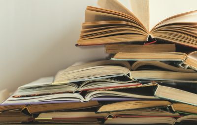 Et billede af bøger der ligger i en stak