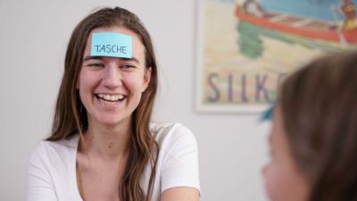 Et billede af en mentor, som underviser i tysk, som griner