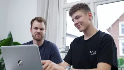 En mentor hjaelper gymnasieelev med lektierne på computer
