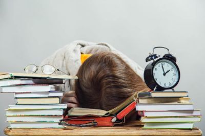 Billede af træt elev der læser til eksamen
